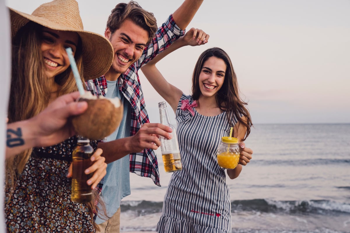 Grupo De Amigos Se Divertindo Na Areia Da Praia Com Drinks